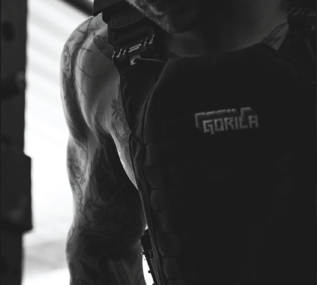 Hyrox Athlete working out with a weight vest on,in black and white in a dark gym ambiance.