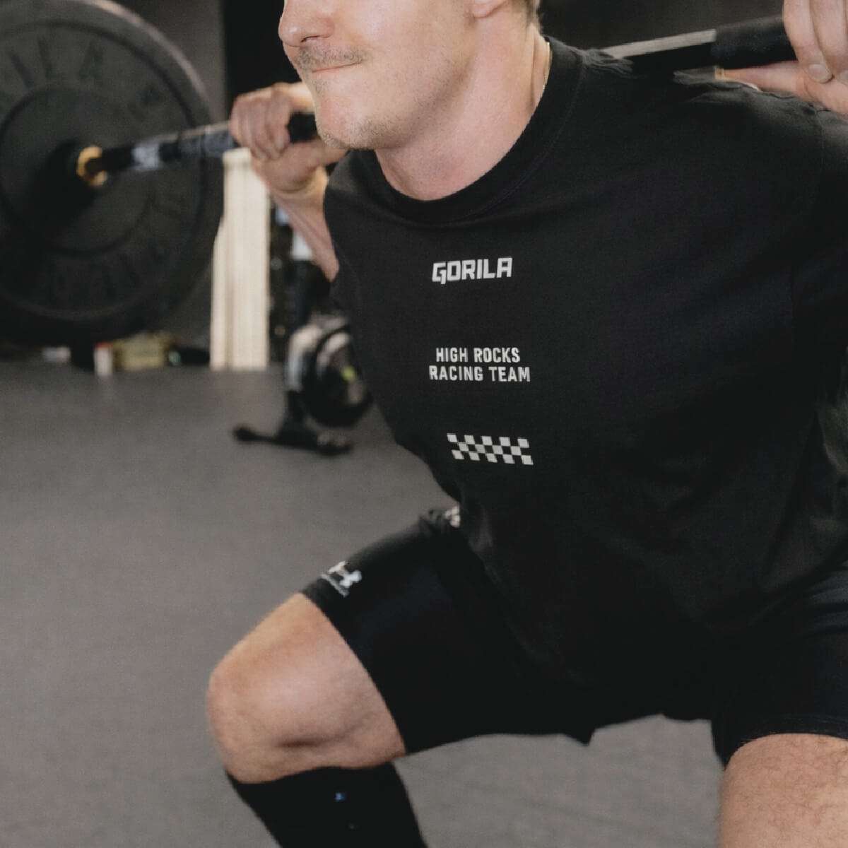 Crossfit Athlete wearing a black 'Gorila Hyrox Racing Team' shirt in a gym setting.