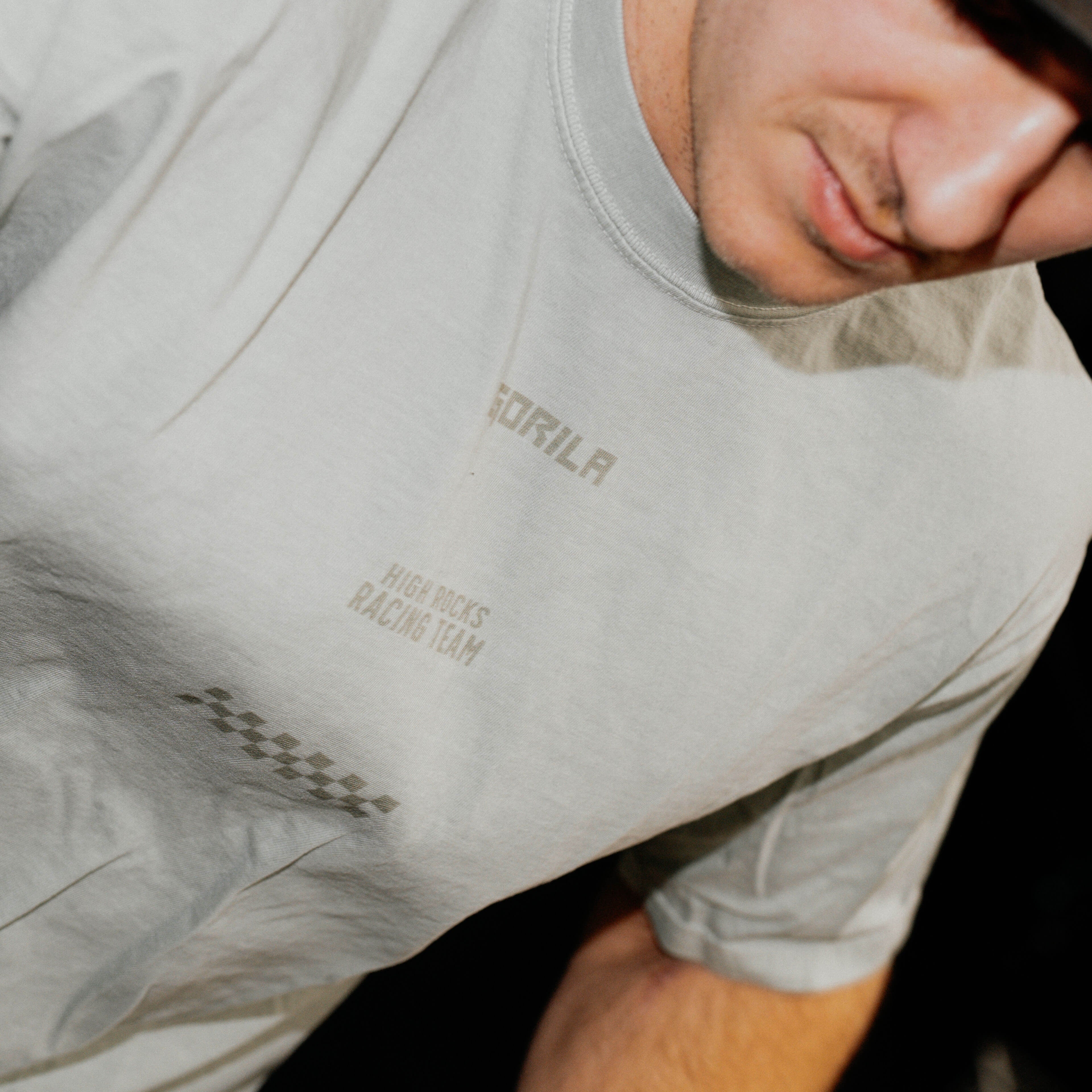 Hybrid athlete wearing a costal green t-shirt with branding on a dark background.