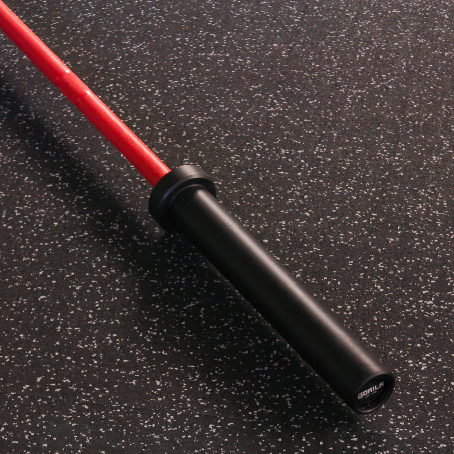 Close-up of the red knurled grip of the Gorila Bee Women's Olympic 2" Barbell Teflon, showcasing its textured surface and sleek design.