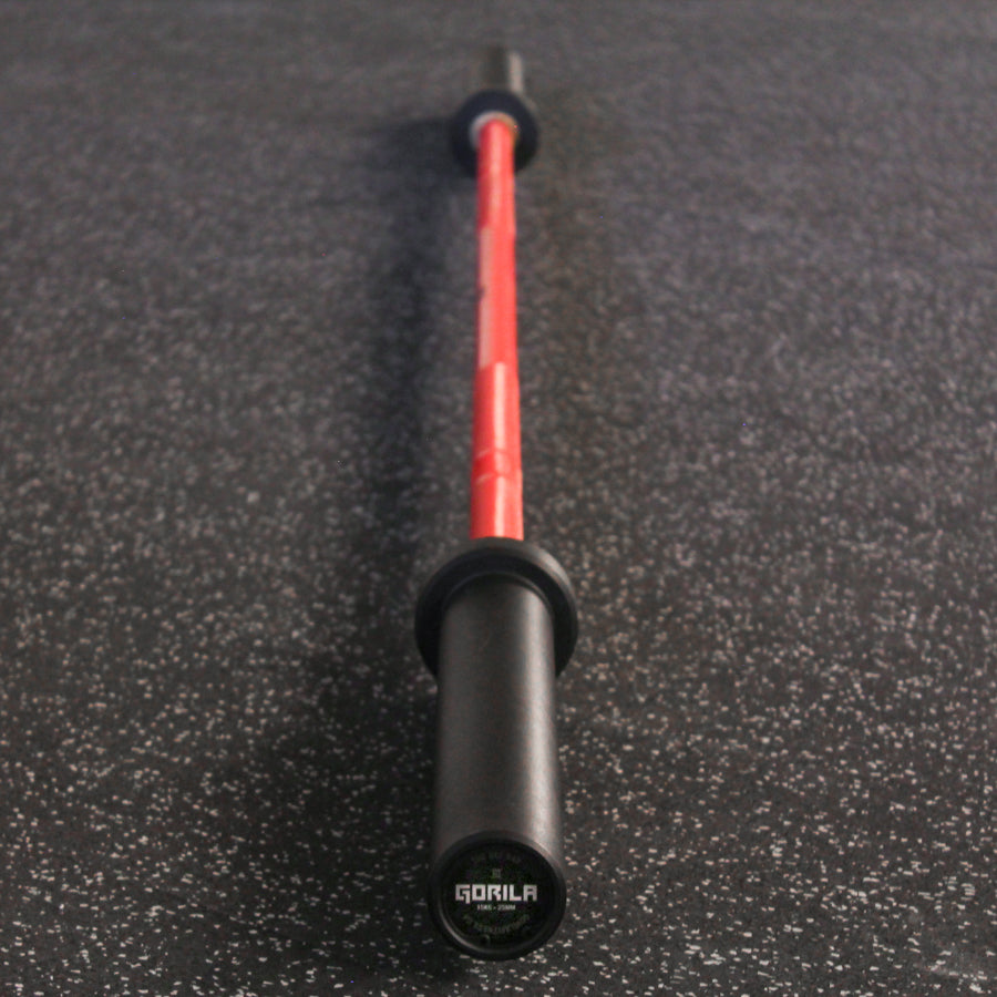 Full-length view of the Gorila Bee Bar Teflon women’s Olympic barbell with a red shaft and black sleeves, designed for durability in group classes.