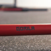 Close-up of the Gorila Bee Bar Teflon featuring the Gorila logo printed on the durable red shaft, showcasing its sleek design and build quality for CrossFit and weightlifting.