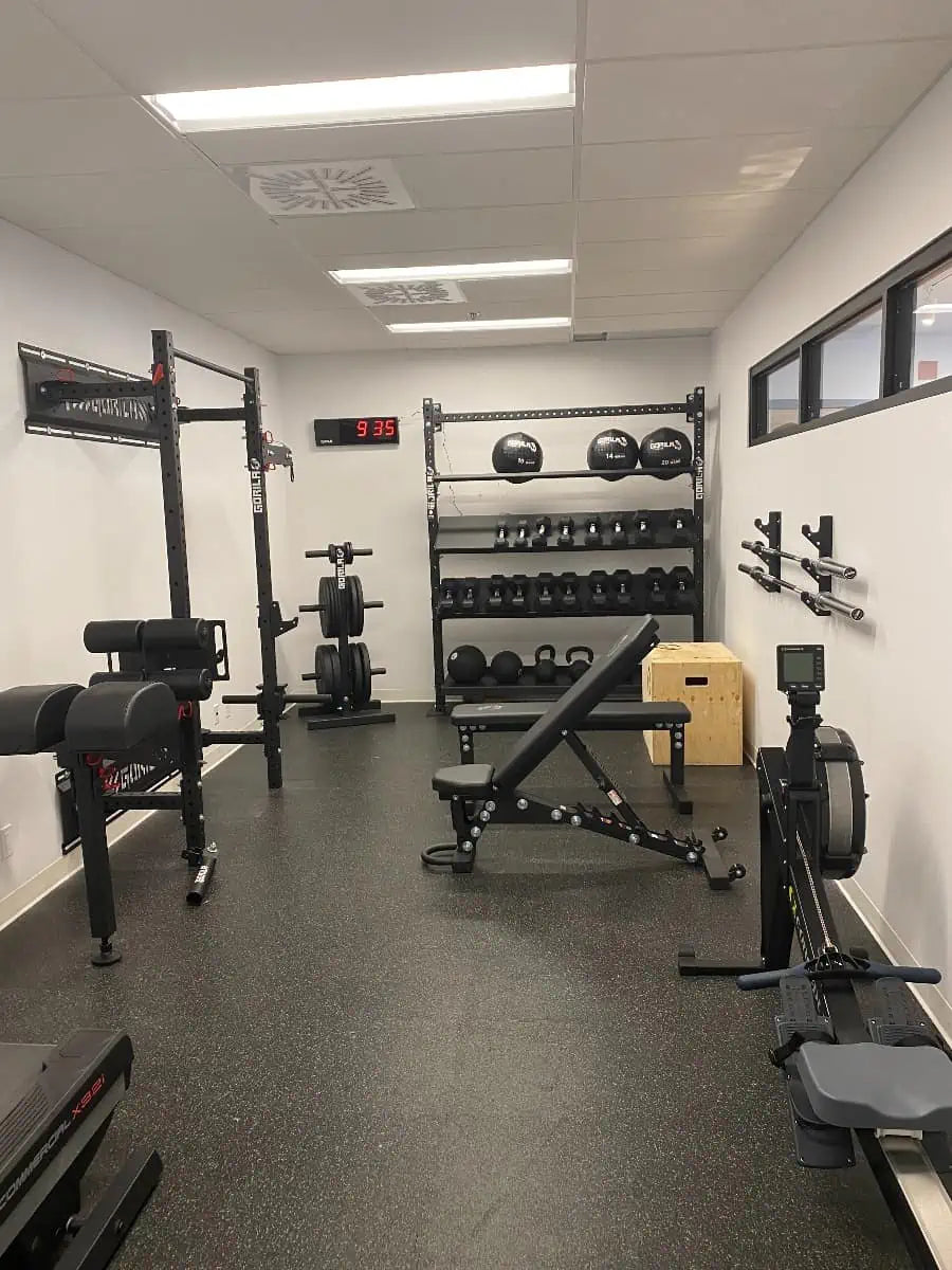 Compact gym setup with premium black Gorila Fitness equipment – power rack, adjustable bench, dumbbells, kettlebells, and wall-mounted storage. Ideal for home gyms and commercial fitness spaces looking to maximize space without sacrificing performance.