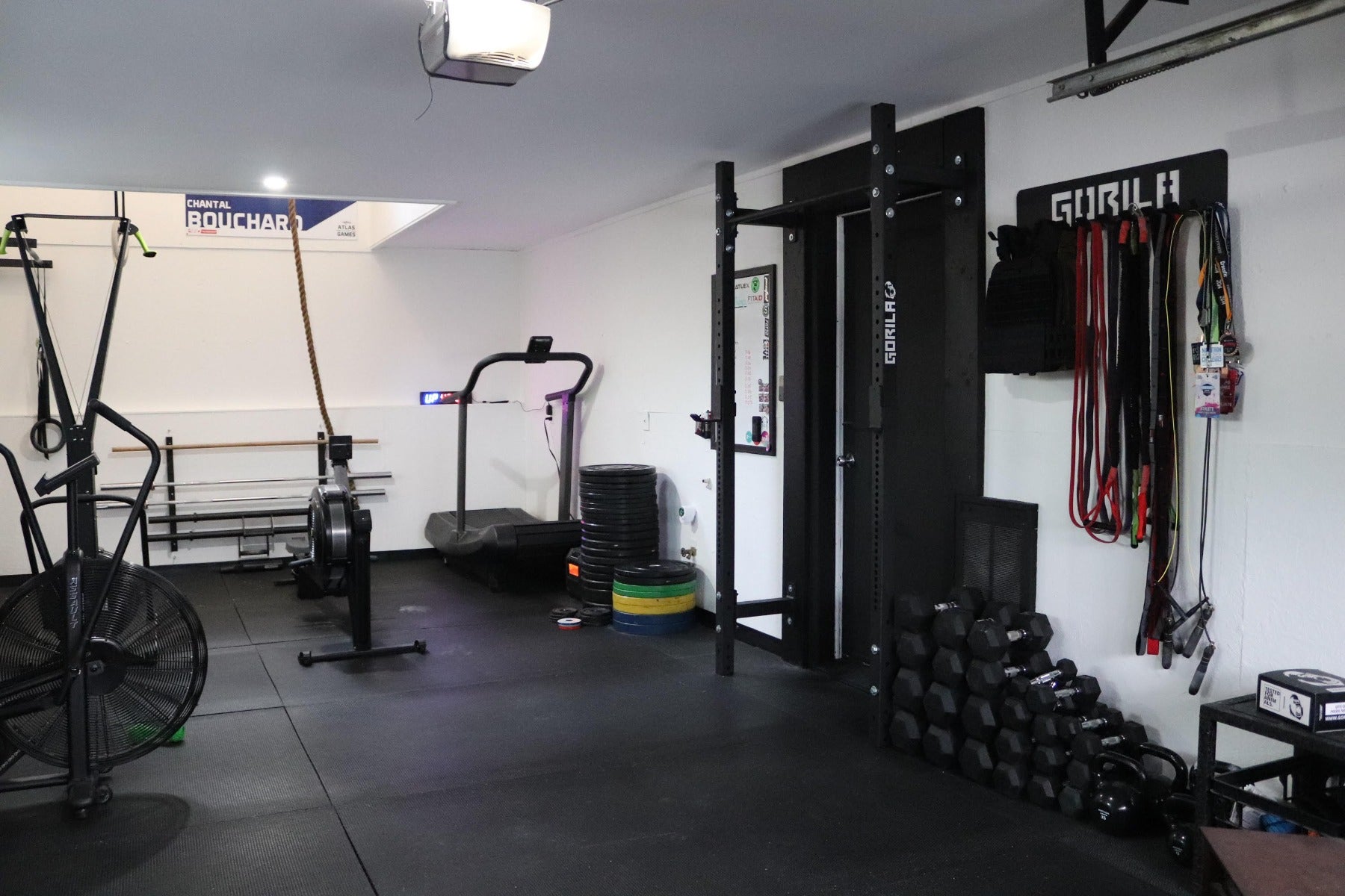 Spacious home gym outfitted with black Gorila Fitness equipment, including pull-up bars, barbells, battle ropes, and functional fitness accessories, tailored for serious athletes and training enthusiasts.