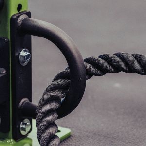 Gorila Conditioning Rope Attachment for 2.5 and 3" rack with 5/8" hole shown on a green power rack with a black conditioning rope going through it.